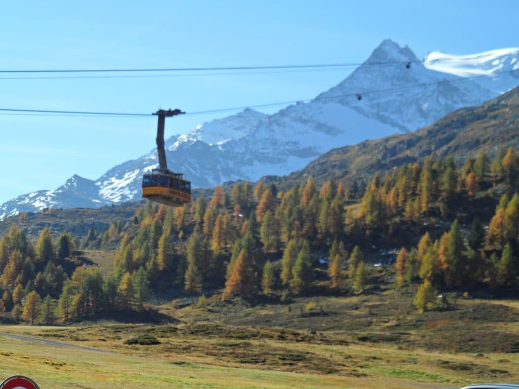 Scenic gondola ride to Diavolezza with snow-capped mountains and autumn foliage on a luxury Swiss adventure