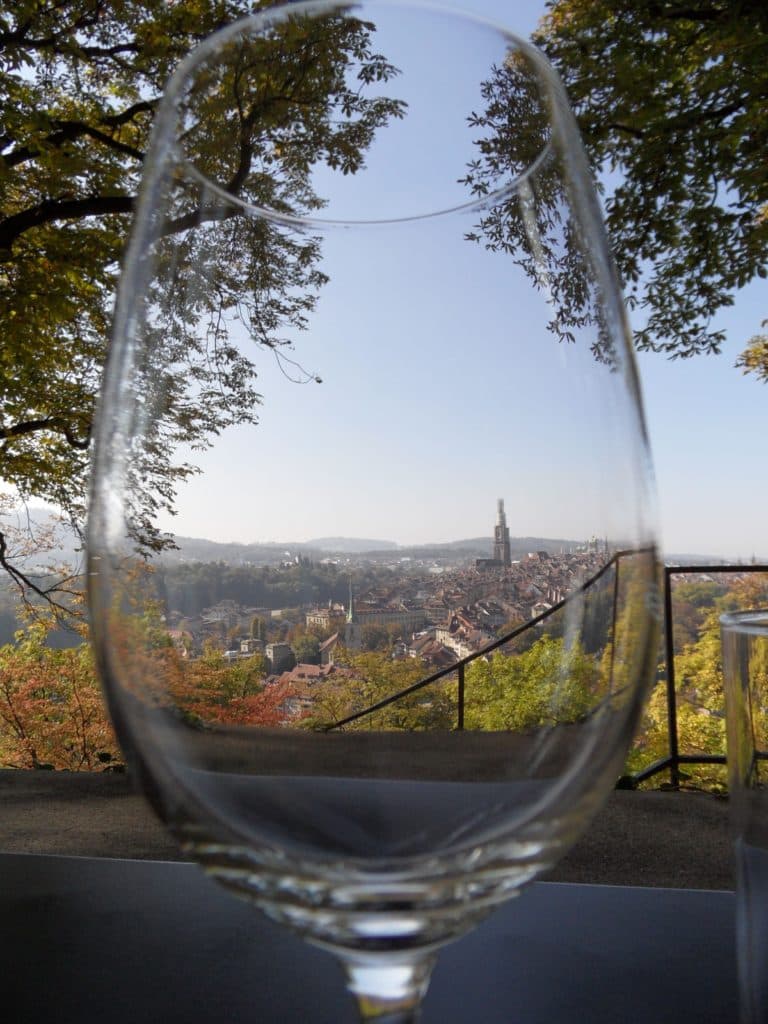 Scenic view of Bern through a wine glass from the Rose Garden during a luxury Swiss adventure