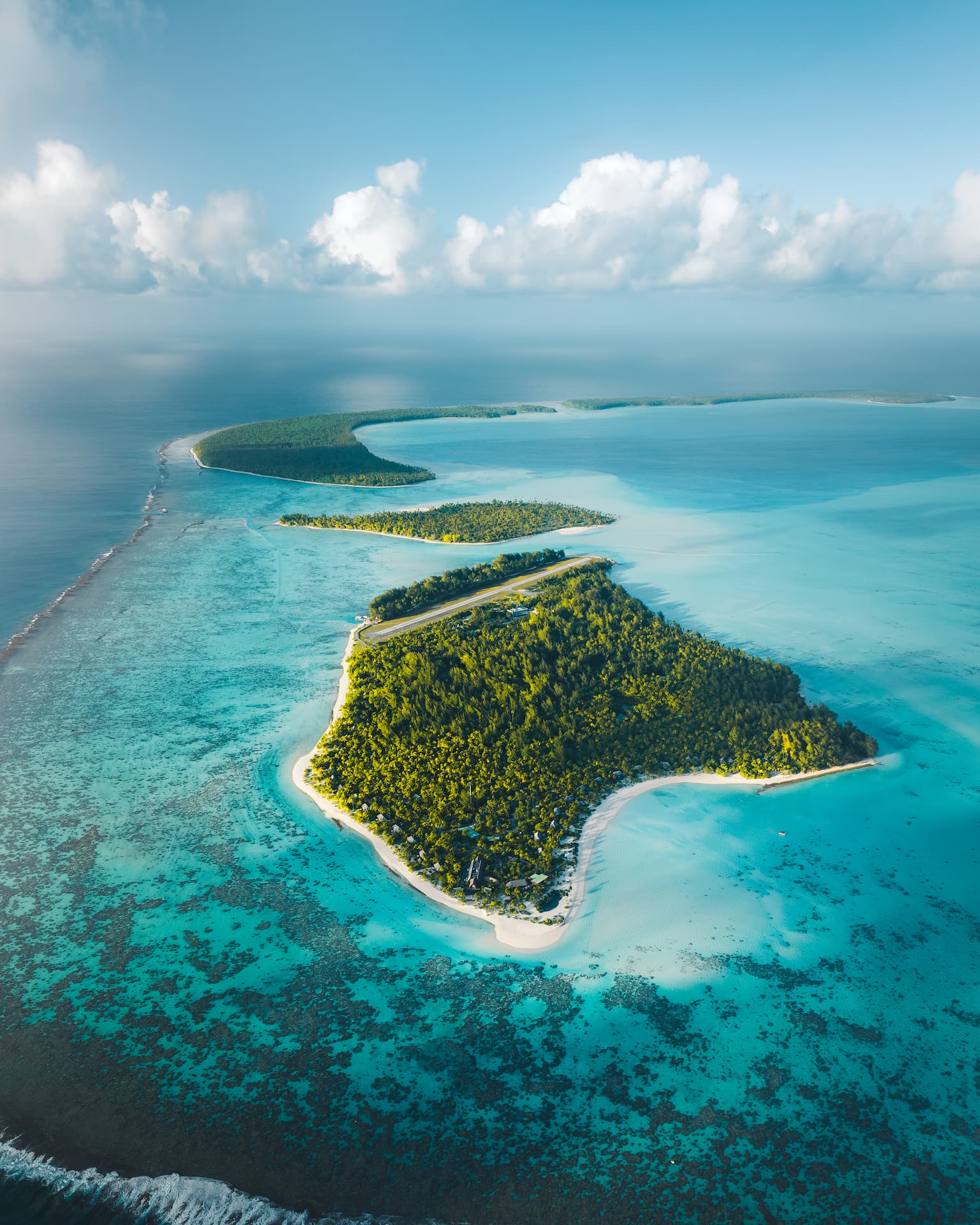 A stunning aerial view of The Brando resort on the Tetiaroa Atoll, including the runway, highlighting Obama's find peace at The Brando Resort.