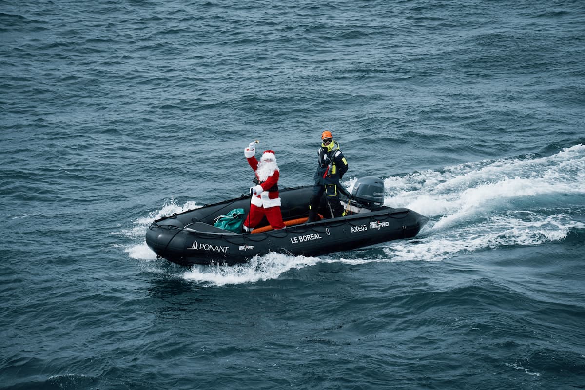 Santa arriving by Zodiac boat to Ponant Le Boréal during a Christmas celebration in Antarctica.