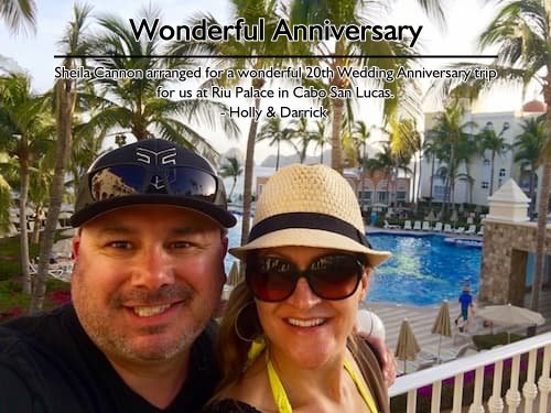 Couple's selfie at the resort pool with Cabo San Lucas mountains in the distance during their 20th Wedding Anniversary trip perfectly coordinated by Sheila Cannon.