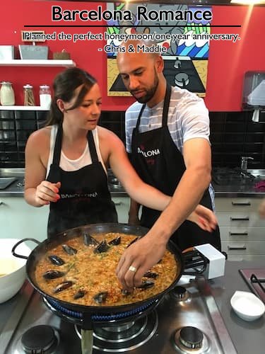 A couple arranging mussels in a large pot of paella during a cooking class in Barcelona, enjoying their perfect romantic vacation planned by Sheila Cannon.