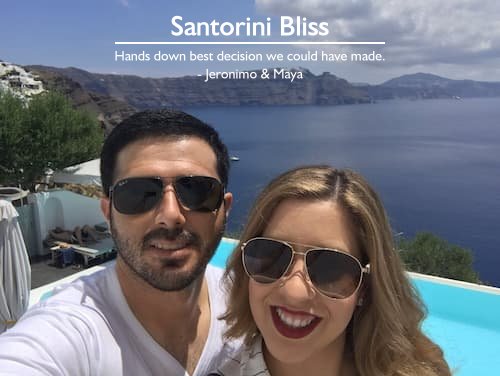 Couple in Santorini, Greece, enjoying a custom honeymoon trip planned by Sheila, relaxing by their private pool overlooking the Mediterranean Sea and the town of Fira.