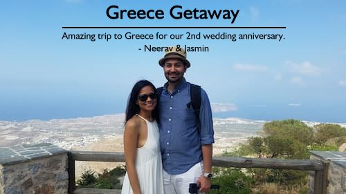 A happy couple smiling at the top of an overlook in Greece, enjoying their anniversary vacation planned by Sheila Cannon with personalized touches.