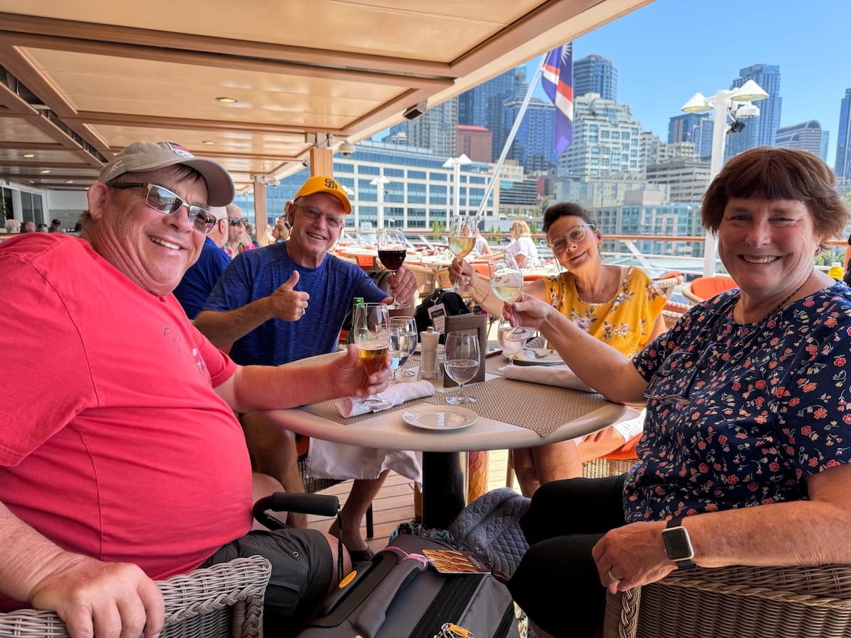 Lucia, Doug, Ric, and Kim enjoying lunch on the Oceania Regatta with Seattle in the background.