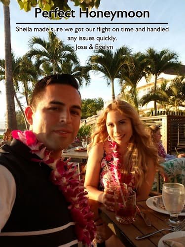 Couple enjoying their honeymoon in Hawaii with flower leis and tropical cocktails, expertly planned by Sheila.