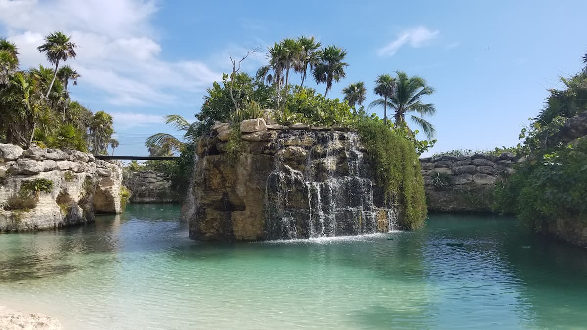 View of the lagoon and waterfall at Hotel Xcaret Mexico surrounded by limestone islands.