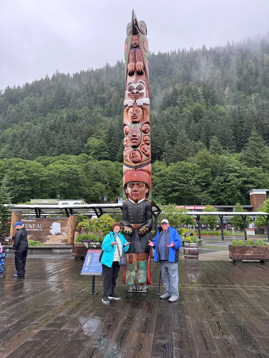 Lucia and Doug posing with a totem pole in Juneau.