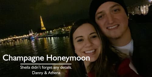 Couple on a Seine river cruise with the Eiffel Tower in the background, part of their luxury Paris and Italy honeymoon planned by Sheila, featuring champagne surprises.