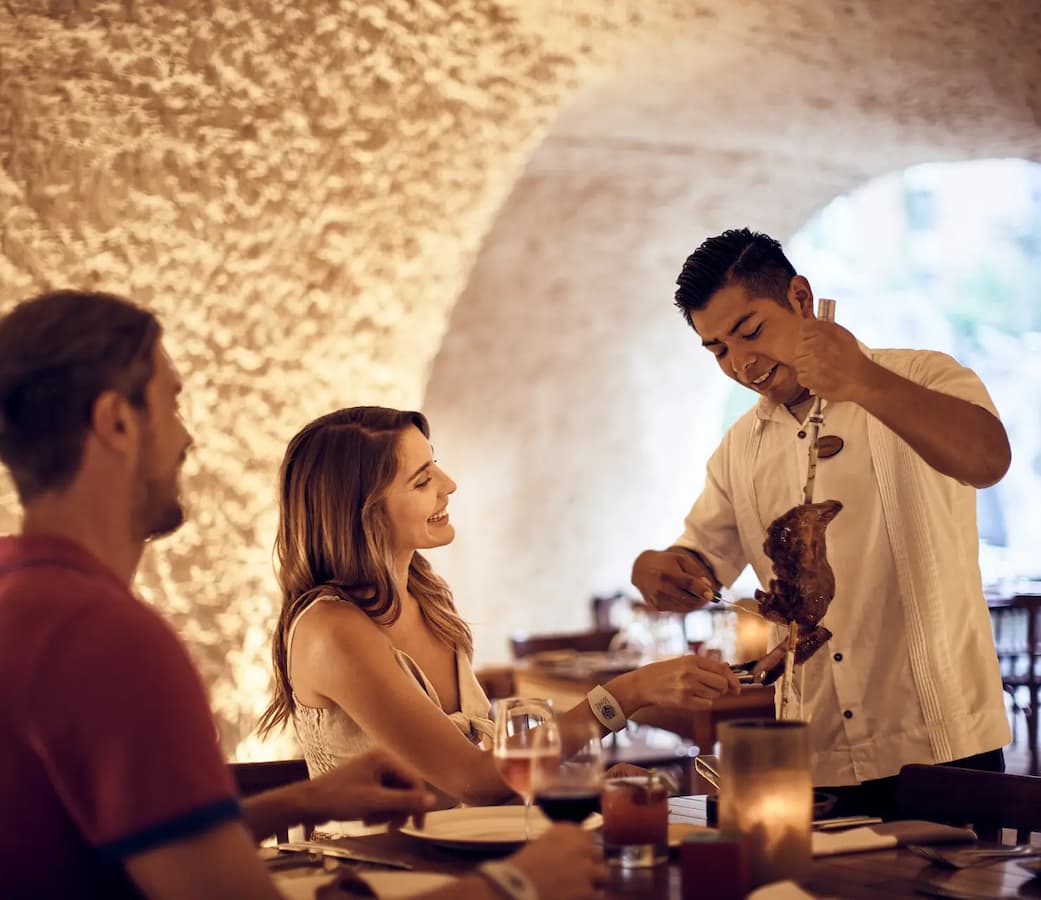 Couple enjoying a romantic dinner at Las Cuevas in Hotel Xcaret Mexico.