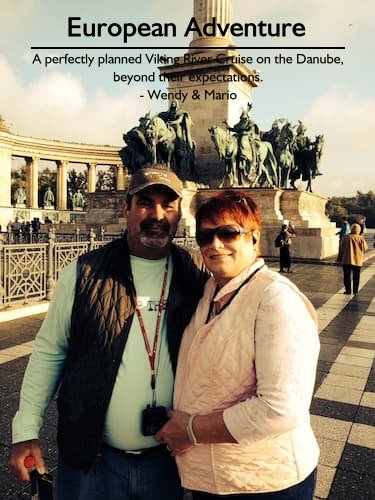 Wendy and Mario on their Viking River Cruise in a European town square with statues of crusaders, planned perfectly by Sheila.