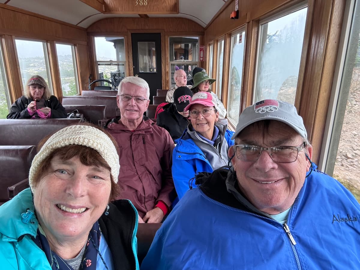 Lucia, Doug, Ric, and Kim riding the White Pass Railway during their Alaska cruise adventure.